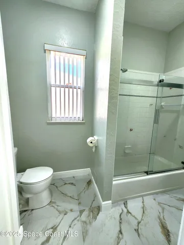 a bathroom with a shower and a glass door