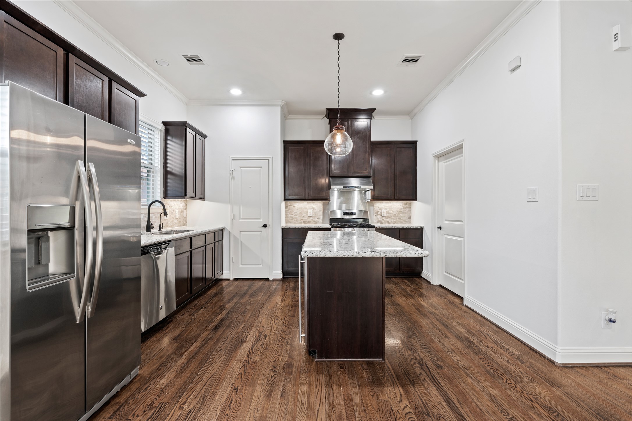 933 West 24th Street, Unit A Houston, TX 77008 - Photo 12 of 41 a kitchen with kitchen island a counter top space a sink appliances and cabinets