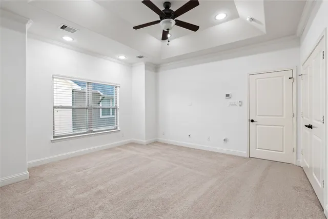 a bedroom with a large bed couch and windows