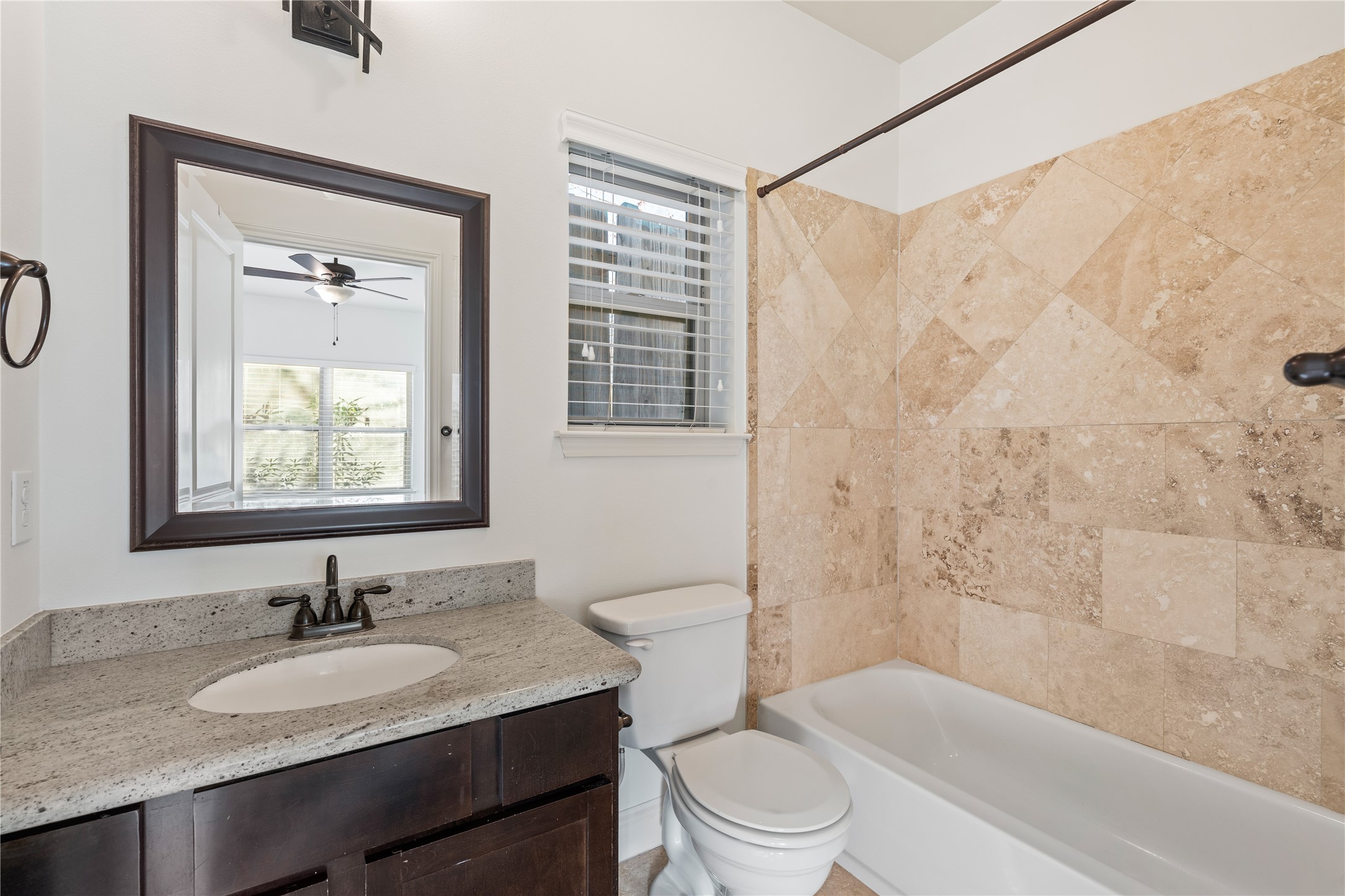 933 West 24th Street, Unit A Houston, TX 77008 - Photo 5 of 41 a bathroom with a granite countertop sink toilet a mirror and shower