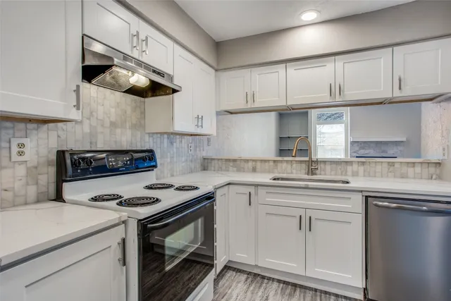 a kitchen with stainless steel appliances granite countertop a sink and cabinets