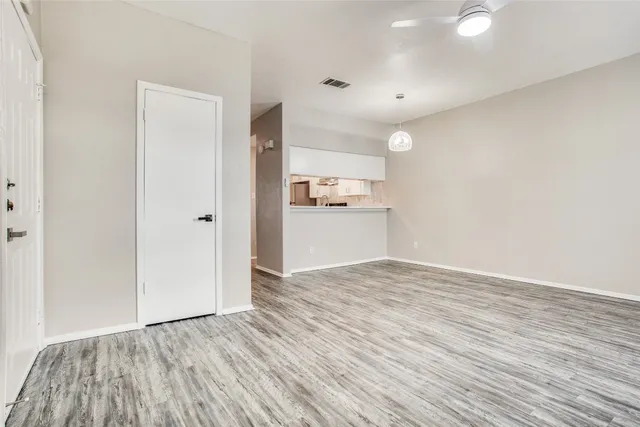 a view of a room with wooden floor and window