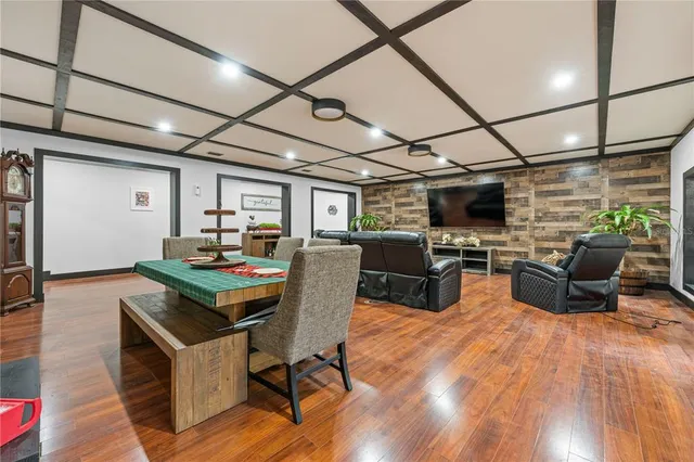 a kitchen with stainless steel appliances granite countertop a sink a stove a refrigerator cabinets and chairs