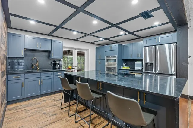 a kitchen with stainless steel appliances granite countertop a refrigerator and a stove