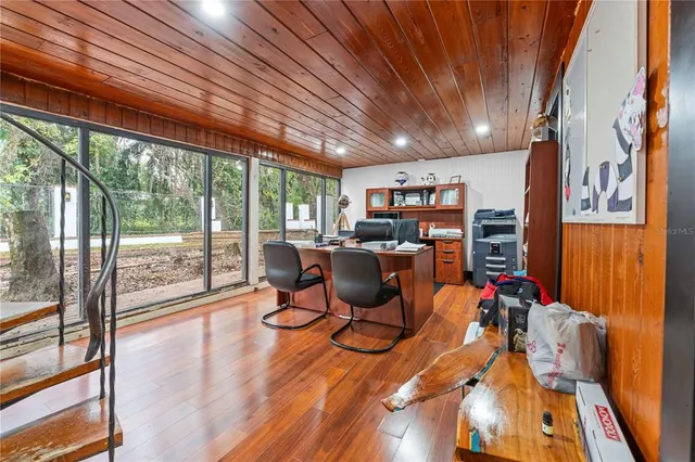 a view of a house with a yard and large trees