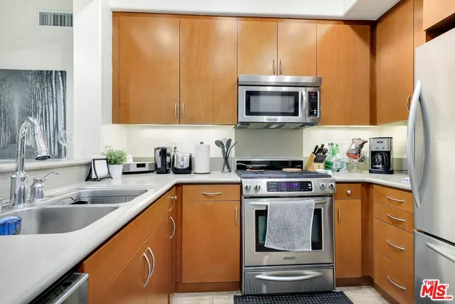 a kitchen with stainless steel appliances granite countertop a sink a stove and a microwave