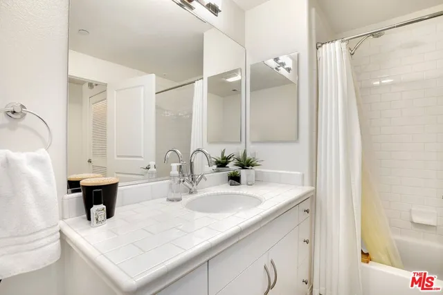 a bathroom with a sink vanity tub and a mirror