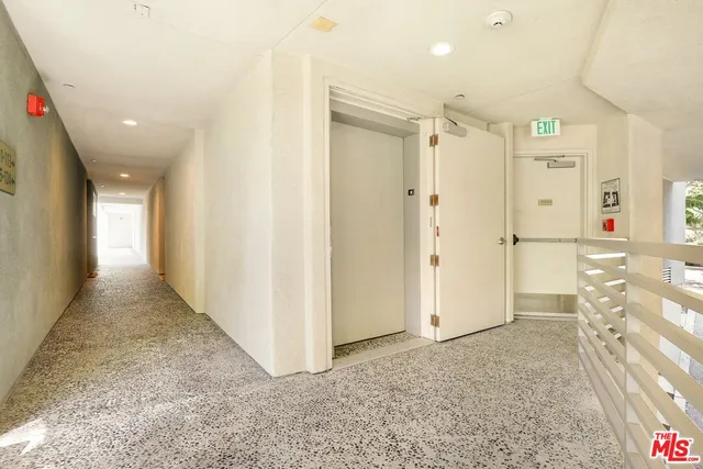 a view of a hallway with wooden floor and a bathroom