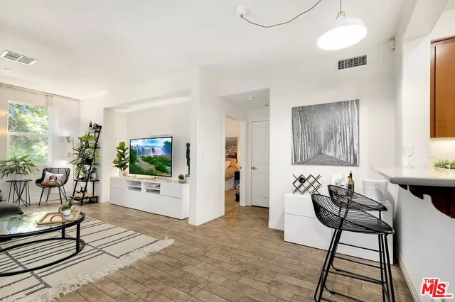 a living room with furniture a flat screen tv and a floor to ceiling window