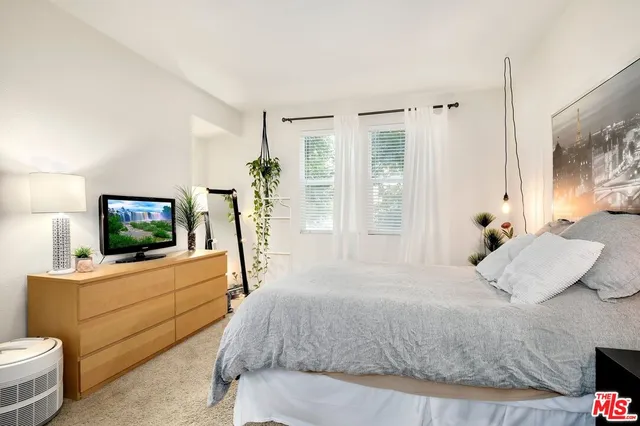 a bedroom with a bed and a flat screen tv