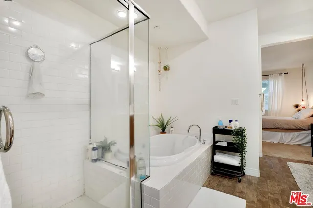 a bathroom with a tub shower and mirror