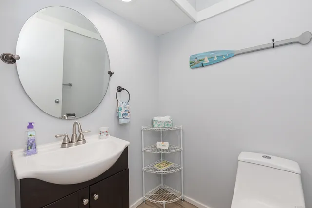 a bathroom with a sink a toilet and a mirror