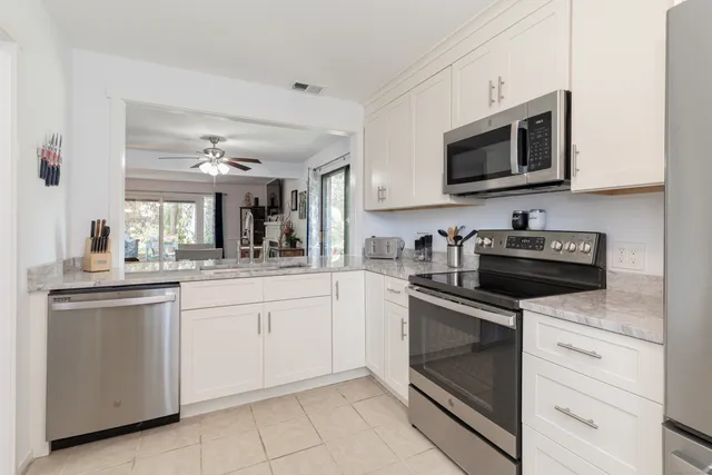 a kitchen with white cabinets and stainless steel appliances
