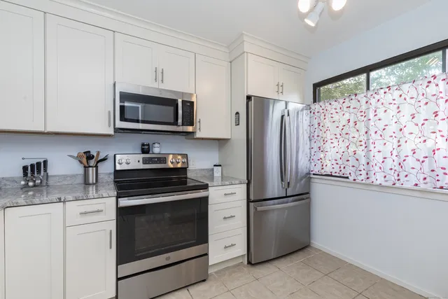 a kitchen with granite countertop cabinets stainless steel appliances and a counter space