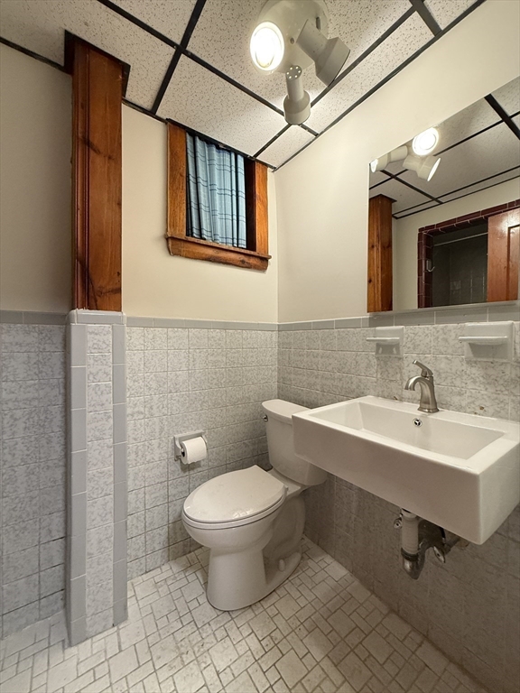 115 Grove Street Brookline, MA 02467 - Photo 11 of 12 a bathroom with a toilet sink and mirror