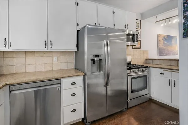 a kitchen with stainless steel appliances granite countertop a refrigerator sink and cabinets