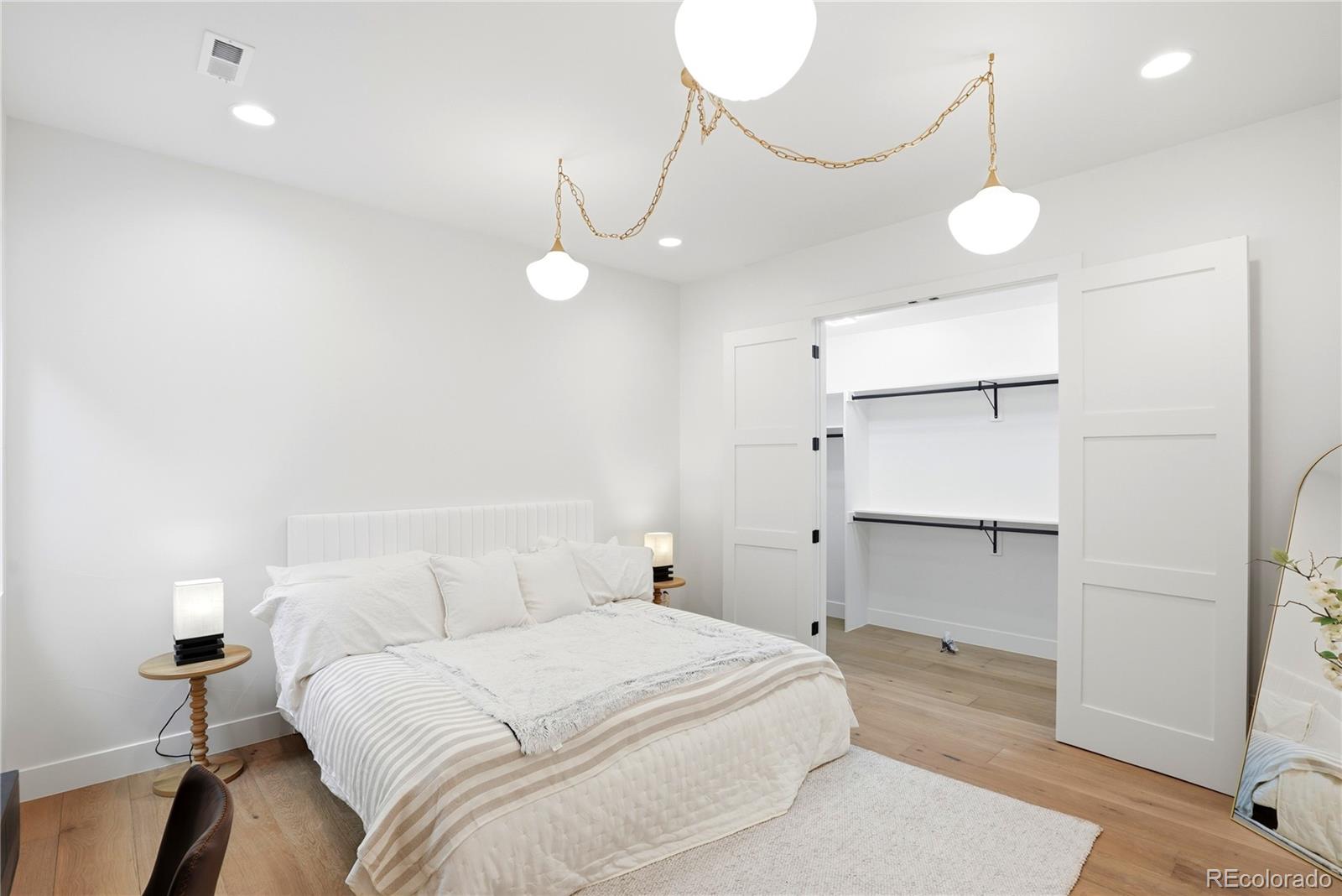 245 South Emerson Street Denver, CO 80209 - Photo 36 of 49 a bedroom with a bed and a chandelier