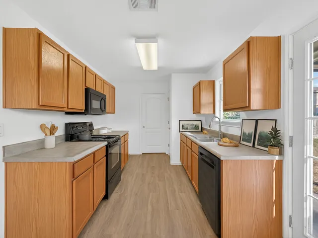 a kitchen with granite countertop a sink stove and cabinets