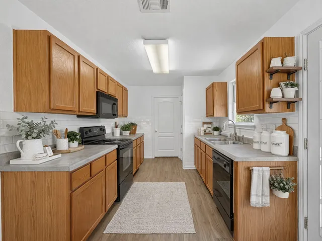 a kitchen with stainless steel appliances granite countertop a sink stove and cabinets
