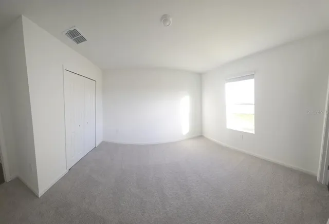 an empty room with windows and closet