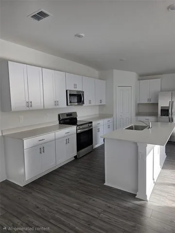 a kitchen with stainless steel appliances white cabinets a sink a stove a microwave and cabinetry