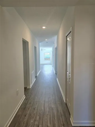 a view of a hallway with wooden floor