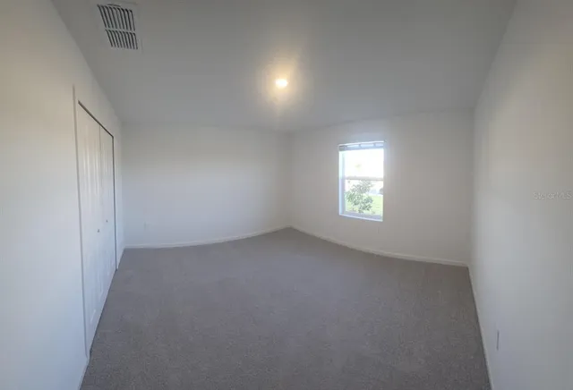 an empty room with a window and doors