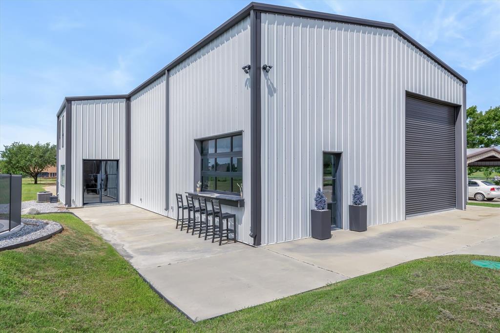 9346 Homestead Lane Forney, TX 75126 - Photo 3 of 39 60 X 50 X 25 foot high shop with 16 ft roll-up bay doors, front and back with drive thru capability -- Custom Mueller I beam bardo build