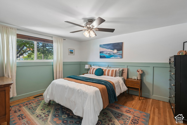 7391 Ramanee Drive Midvale, UT 84047 - Photo 13 of 45 Hardwood flooring, picture window, ceiling fan with integrated lighting, two-tone walls with wainscoting, and recessed lighting