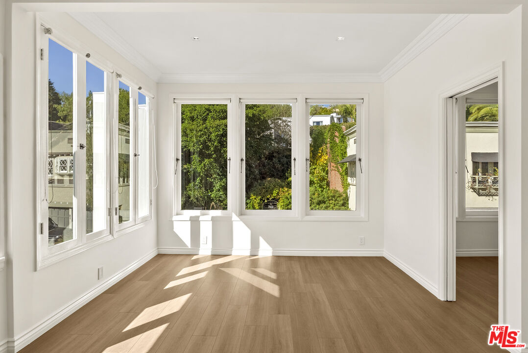 1326 Londonderry View Drive, Unit 4 Los Angeles, CA 90069 - Photo 17 of 29 a view of an empty room with wooden floor and a window