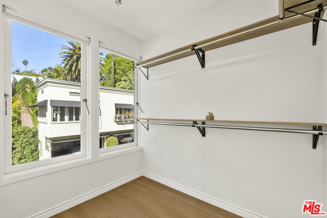 1326 Londonderry View Drive, Unit 4 Los Angeles, CA 90069 - Photo 22 of 29 a view of walk in closet with window and wooden floor