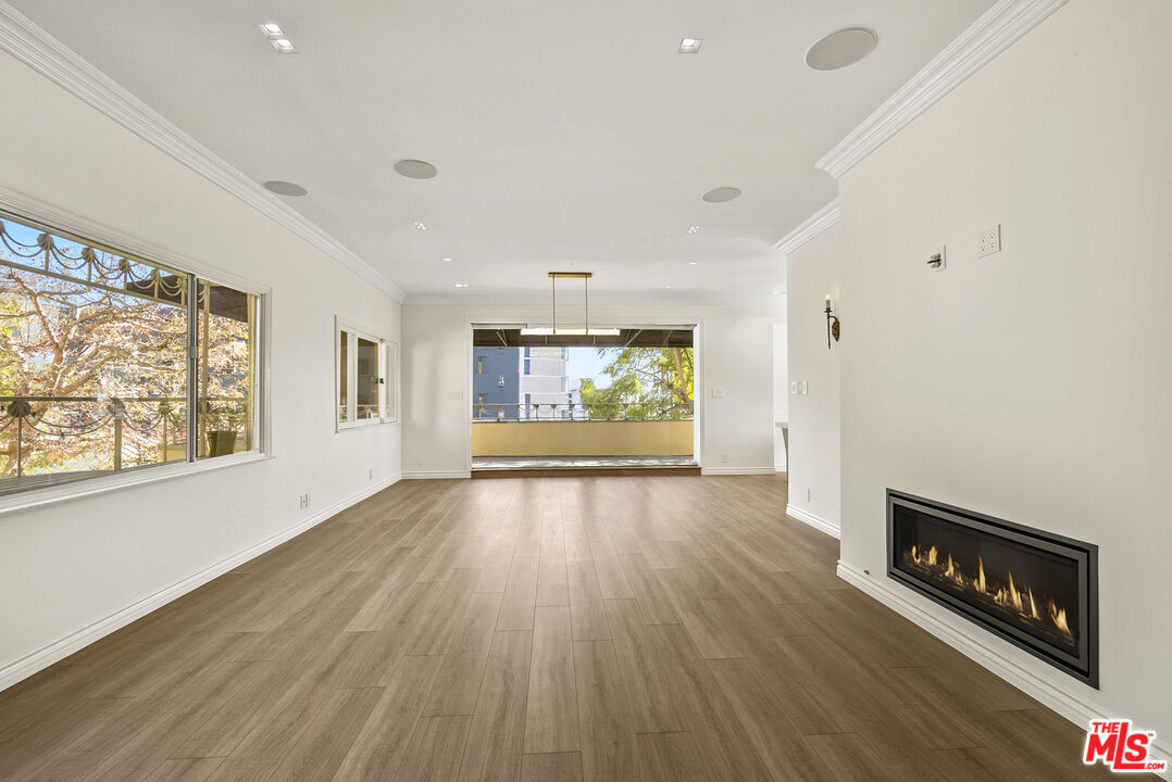 1326 Londonderry View Drive, Unit 4 Los Angeles, CA 90069 - Photo 3 of 29 an empty room with wooden floor and windows