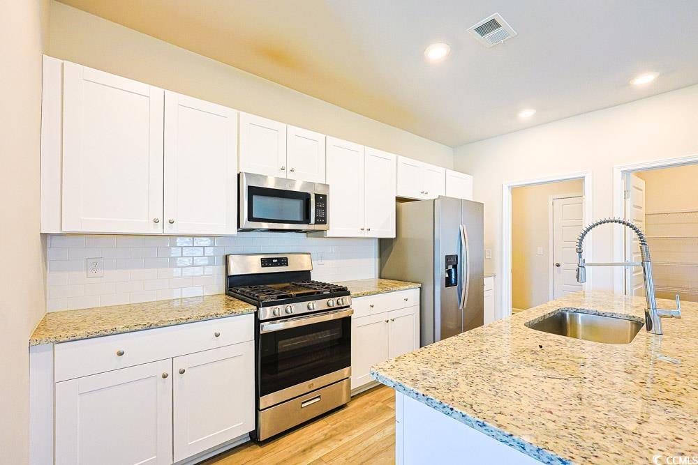 1560 Swing Bridge Way Myrtle Beach, SC 29588 - Photo 5 of 35 Kitchen with stainless steel appliances, white cabinetry, backsplash, light stone counters, and recessed lighting