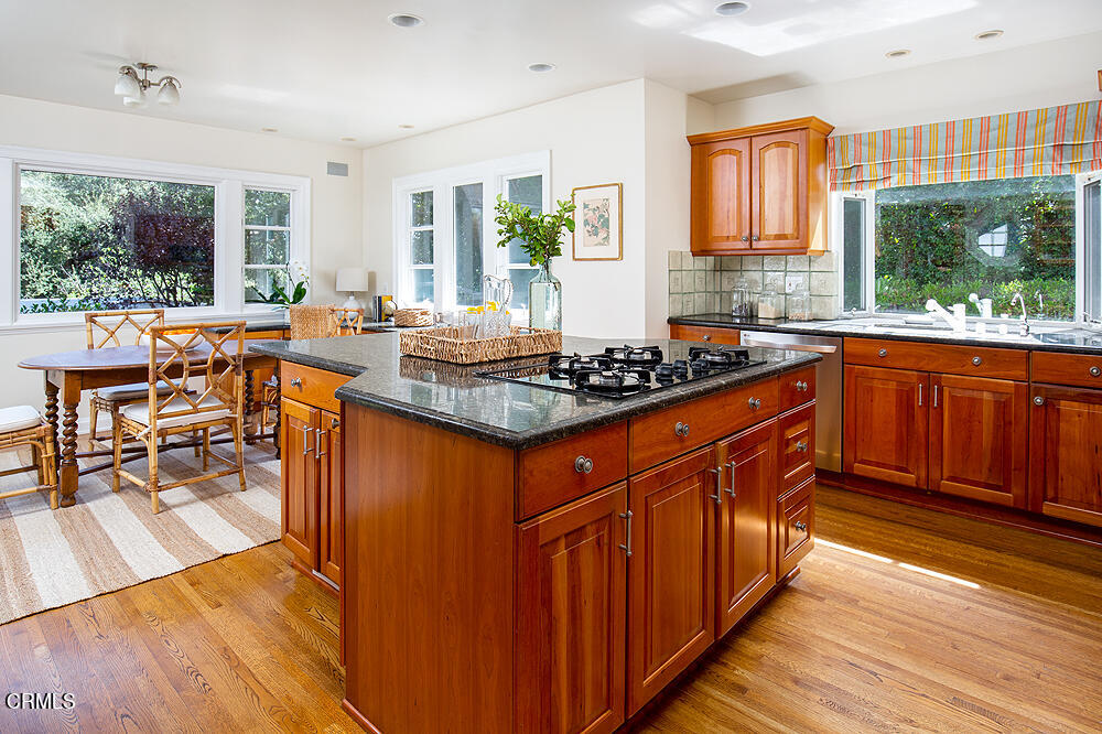141 Sierra View Road Pasadena, CA 91105 - Photo 10 of 38 a kitchen with stainless steel appliances granite countertop a stove a sink dishwasher and a dining table with cabinets