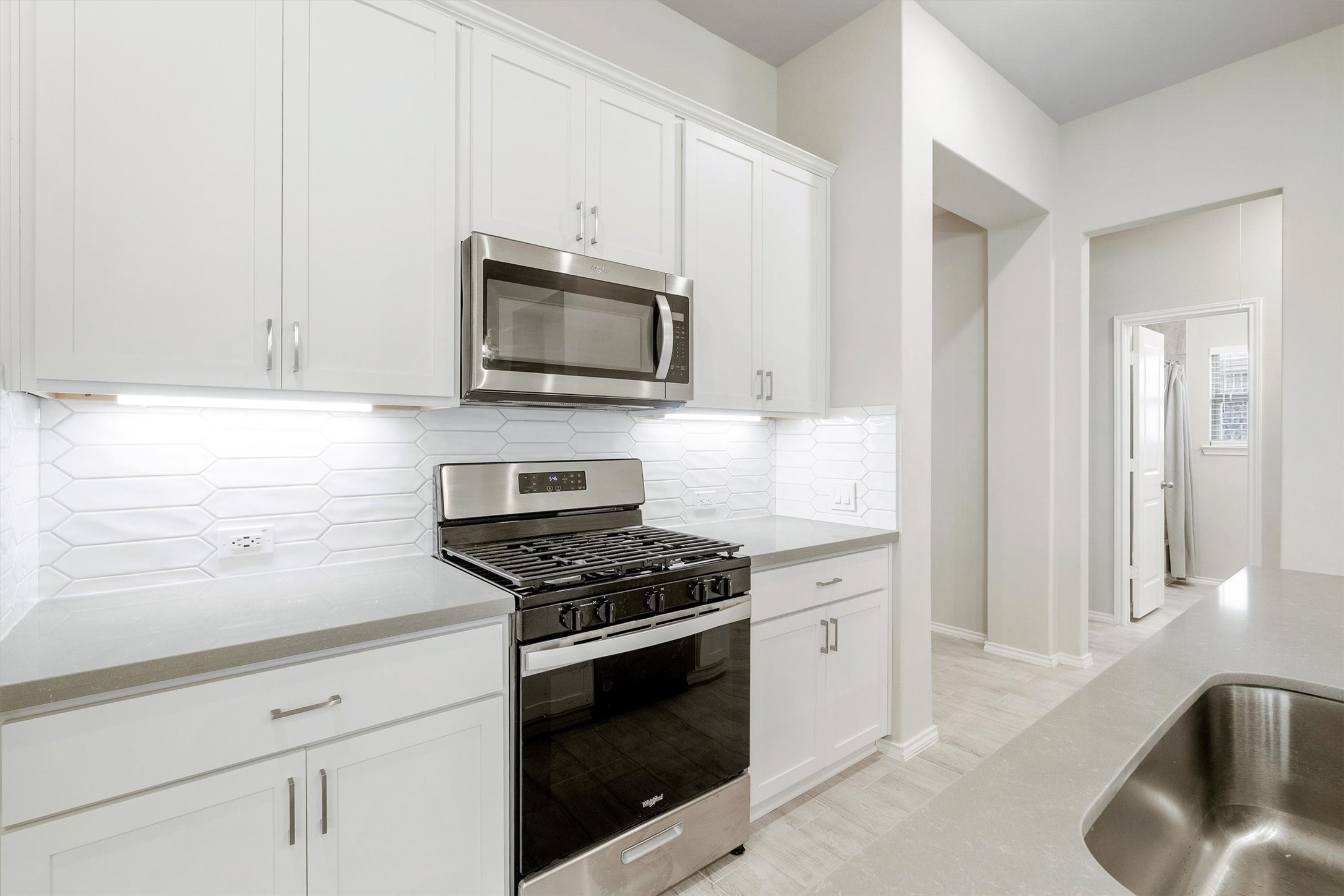 17270 Wild Watermelon Way Conroe, TX 77302 - Photo 8 of 28 The details make the difference. Under-cabinet lighting and stainless steel appliances including a gas range and built-in microwave. Everything here was designed to make cooking feel less like a chore and more like a vibe.