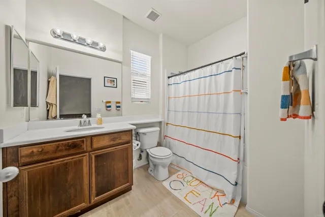 a bathroom with a sink a toilet a mirror and shower