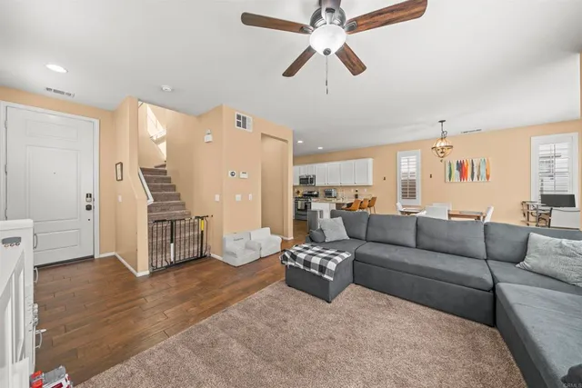 a living room with furniture and a wooden floor