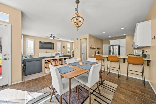 a view of a dining room with furniture a chandelier and wooden floor
