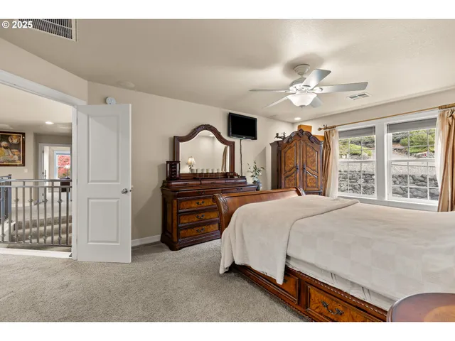 a spacious bedroom with a bed and a chandelier