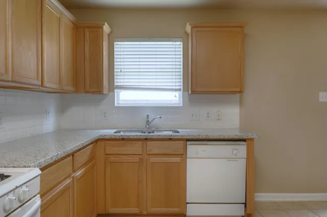 a kitchen with a sink cabinets and a window