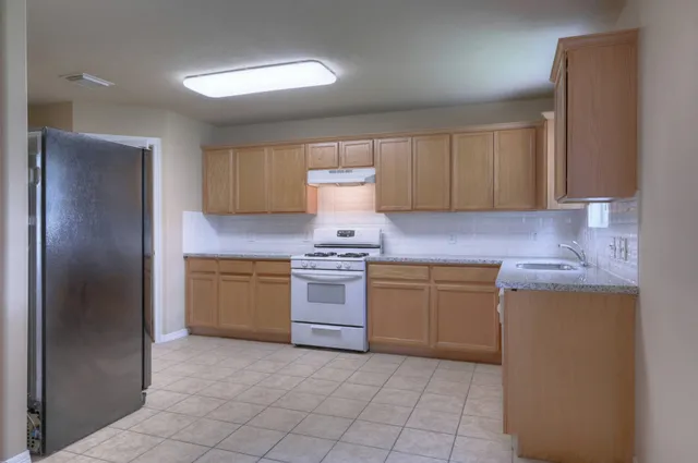 a kitchen with a stove sink and cabinets