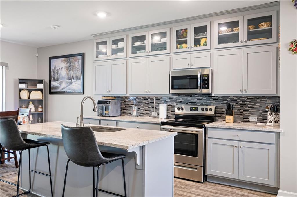 406 Splash Pointe Temple, GA 30179 - Photo 12 of 33 a kitchen with stainless steel appliances granite countertop a stove top oven a sink a dining table and chairs