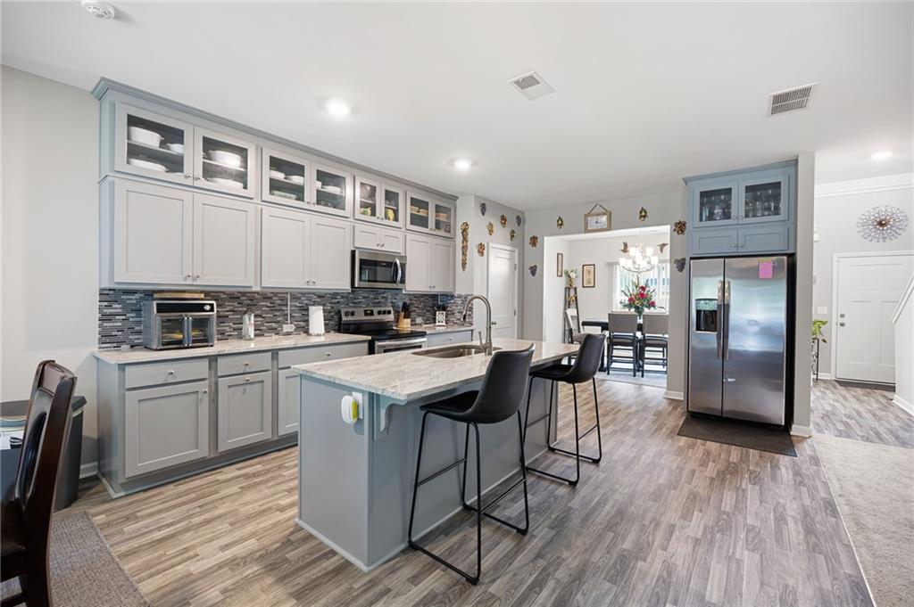 406 Splash Pointe Temple, GA 30179 - Photo 15 of 33 a kitchen with stainless steel appliances granite countertop a refrigerator a stove top oven a sink dishwasher and white cabinets with wooden floor