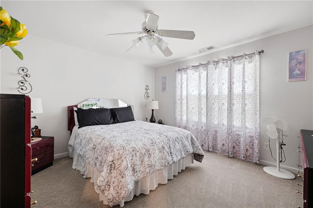 406 Splash Pointe Temple, GA 30179 - Photo 29 of 33 a spacious bedroom with a bed and a chandelier