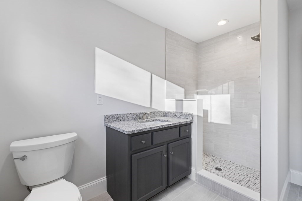 430 High Street Walpole, MA 02081 - Photo 21 of 42 a bathroom with a granite countertop toilet sink and mirror