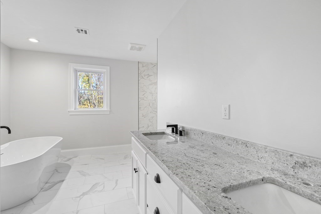 430 High Street Walpole, MA 02081 - Photo 27 of 42 a bathroom with a granite countertop sink and mirror with bathtub