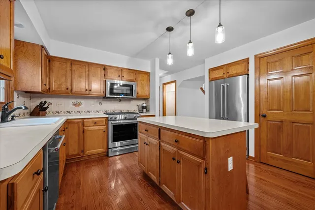 a kitchen with stainless steel appliances granite countertop a stove refrigerator and a sink