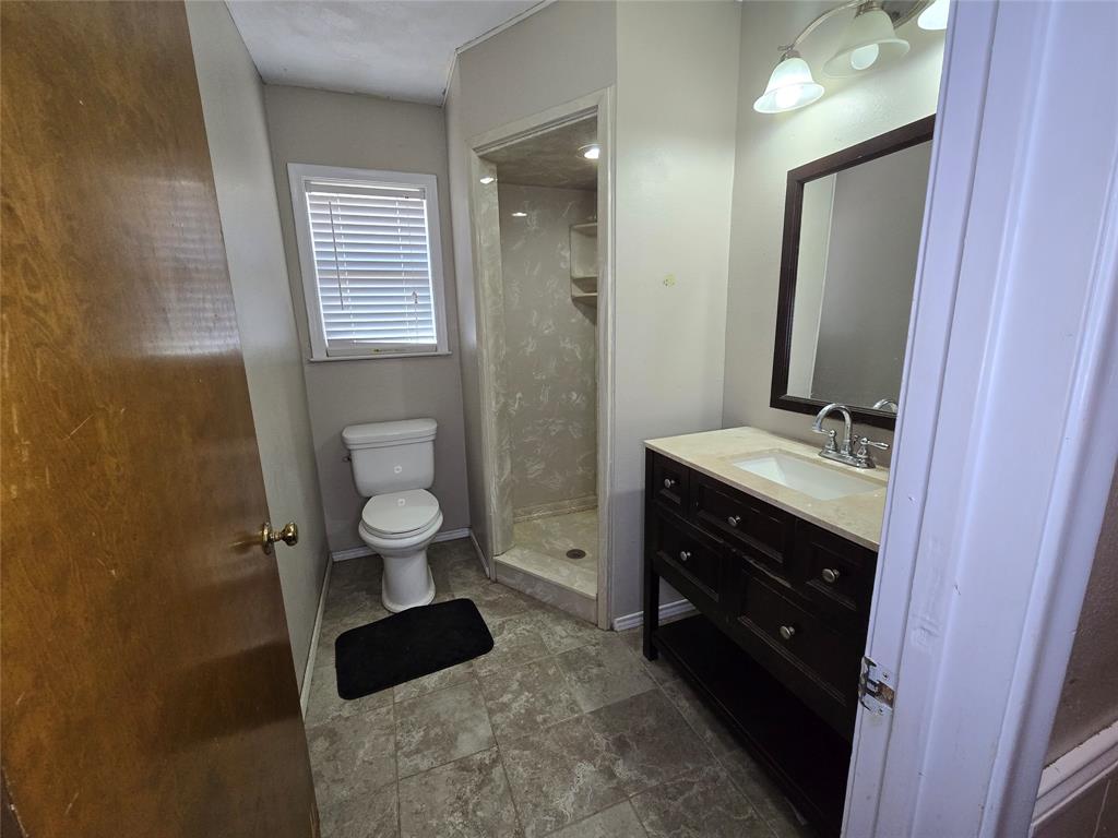 201 Robin Way Mount Vernon, TX 75457 - Photo 17 of 28 a bathroom with a double vanity sink toilet and shower