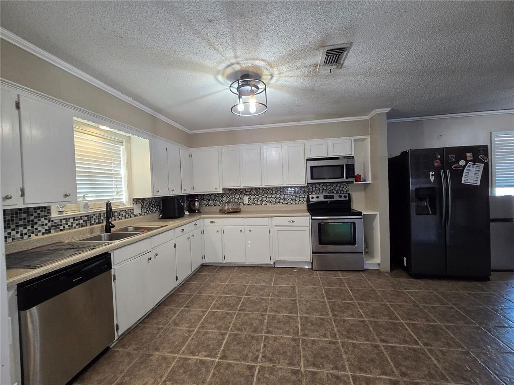 201 Robin Way Mount Vernon, TX 75457 - Photo 8 of 28 a large kitchen with a stove top oven cabinets and stainless steel appliances