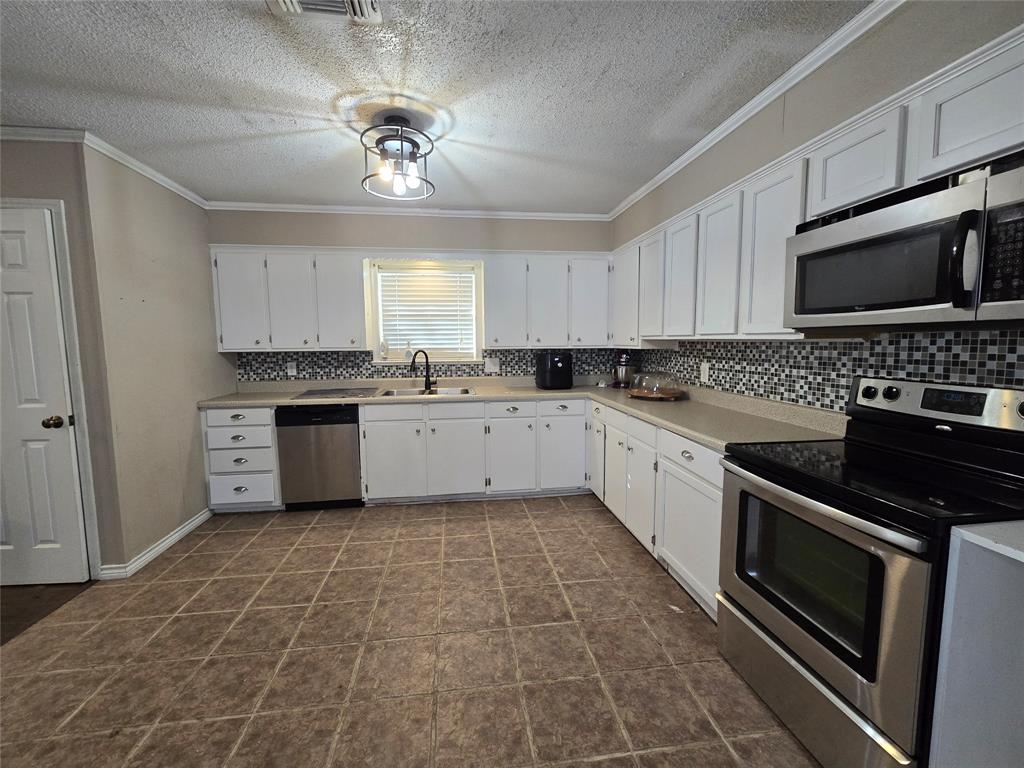 201 Robin Way Mount Vernon, TX 75457 - Photo 9 of 28 a kitchen with a sink stove and microwave